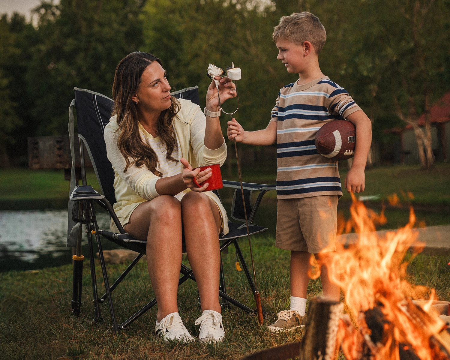A mother and son take a fire-roasted marshmallow off a roasting fork by the firepit at Santa's Cottages in Santa Claus, Indiana.